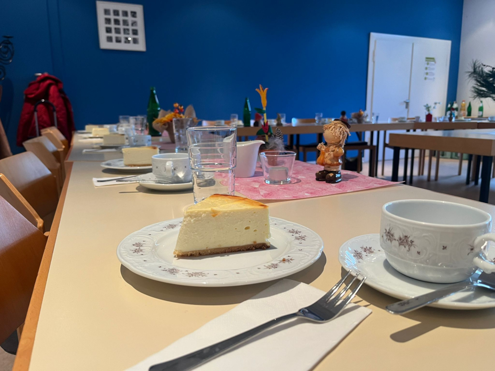 Käsekuchen auf gedecktem Tisch vor blauer Wand