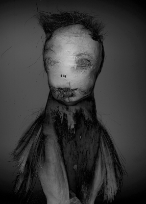 Schwarz-Weiß-Foto einer unheimlichen Puppe mit struppigem Haar.