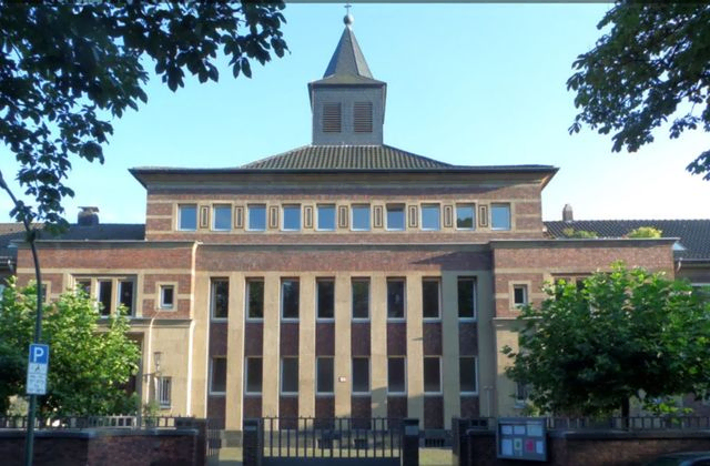 Historisches Gebäude mit klassischer Architektur und einem Turm auf dem Dach.